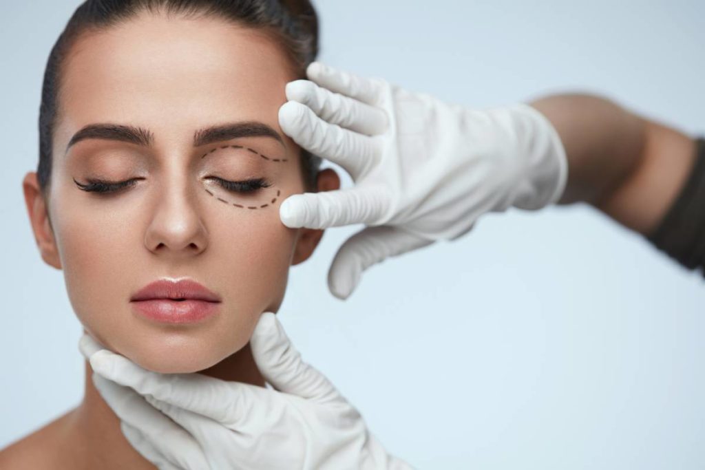 image of Closeup Of Beautician Hands Touching Young Female Patient Face